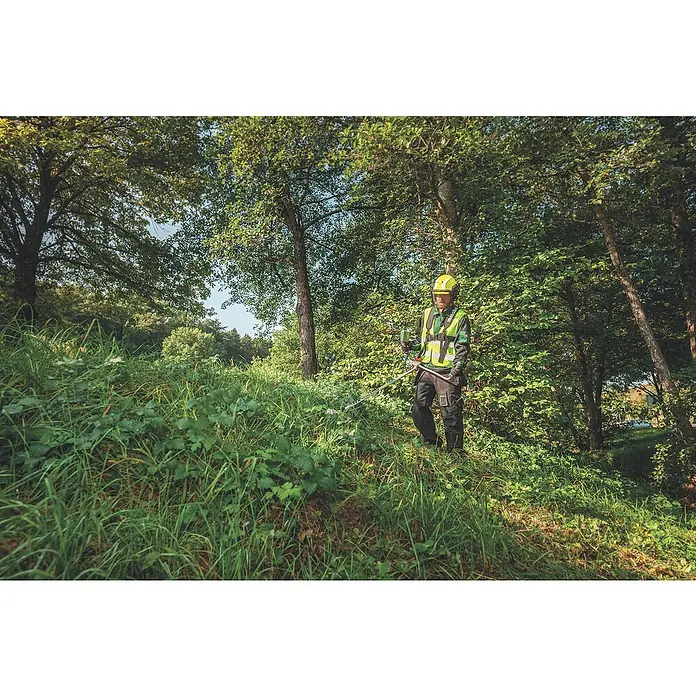 Metabo CAS 18V Akku-Rasentrimmer FSB 36-18 LTX BL 40 - 18 V, 2 Ah, Ohne Akku, Schnittbreite Faden: 40 cm - Ein Waldarbeiter mit Schutzhelm und Sicherheitsweste, der im Wald arbeitet, mit Freischneider.