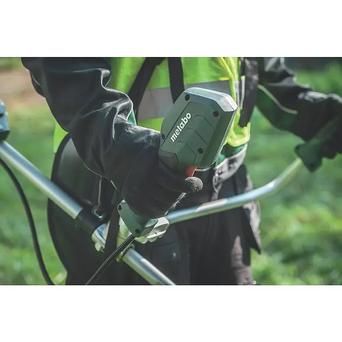 Metabo CAS 18V Akku-Rasentrimmer FSB 36-18 LTX BL 40 - 18 V, 2 Ah, Ohne Akku, Schnittbreite Faden: 40 cm - Nahaufnahme des Metabo-Rasentrimmers in Aktion, mit Fokus auf Bedienelemente und ergonomisches Design für komfortables Arbeiten.