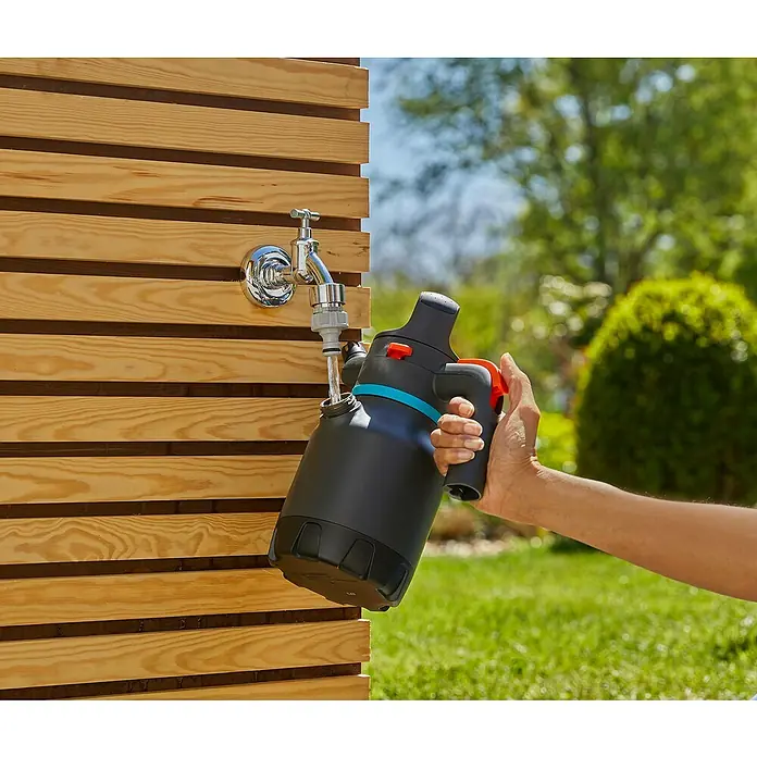 Gardena Drucksprüher - 1,25 l - Eine Person befüllt einen Gardena Akku-Drucksprüher mit Wasser an einem Wasserhahn im Freien.