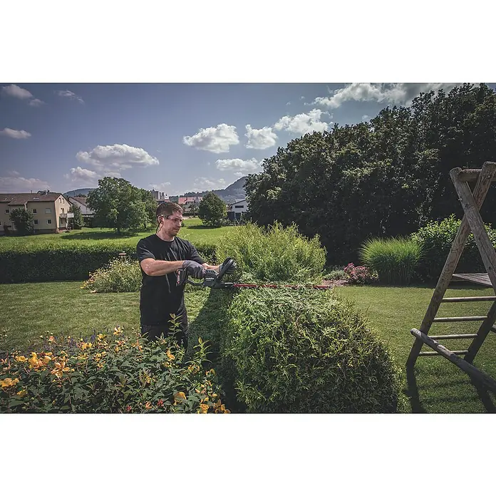 Metabo CAS 18V Akku-Heckenschere HS 18 LTX 45 - 18 V, Li-Ionen, Ohne Akku, Schwertlänge: 45 cm - Ein Mann schneidet mit einer Metabo Heckenschere eine Hecke im Garten. Die Metabo Heckenschere ermöglicht präzise Schnitte für eine gepflegte Gartenlandschaft.