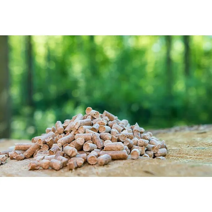 Fireland Holzpellets - 15 kg - Nahaufnahme von Holzpellets, einem Biomasse-Brennstoff, auf einer Holzoberfläche mit verschwommenem grünem Hintergrund.