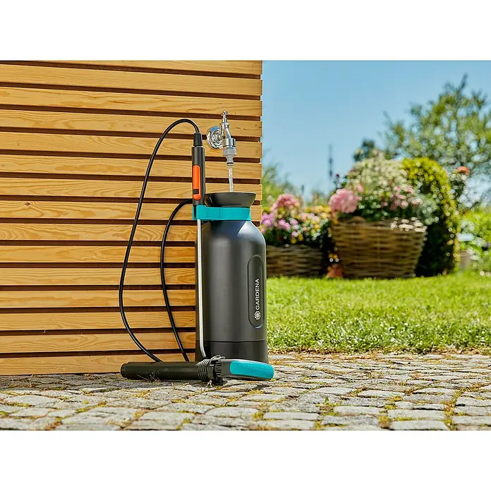 Gardena Comfort Drucksprüher - Füllmenge: 5 l, Grau - Das Bild zeigt ein Gardena Produkt: Eine tragbare Gartendusche, die an einem Holzrahmen befestigt ist und sich ideal für den Garten eignet.