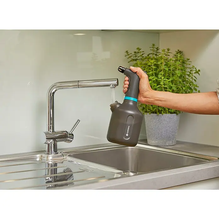Gardena Handsprüher Easy Pump1 l - Ein GARDENA-Drucksprüher wird unter einem Wasserhahn in einer Spüle befüllt, um ihn für die Gartenarbeit vorzubereiten.
