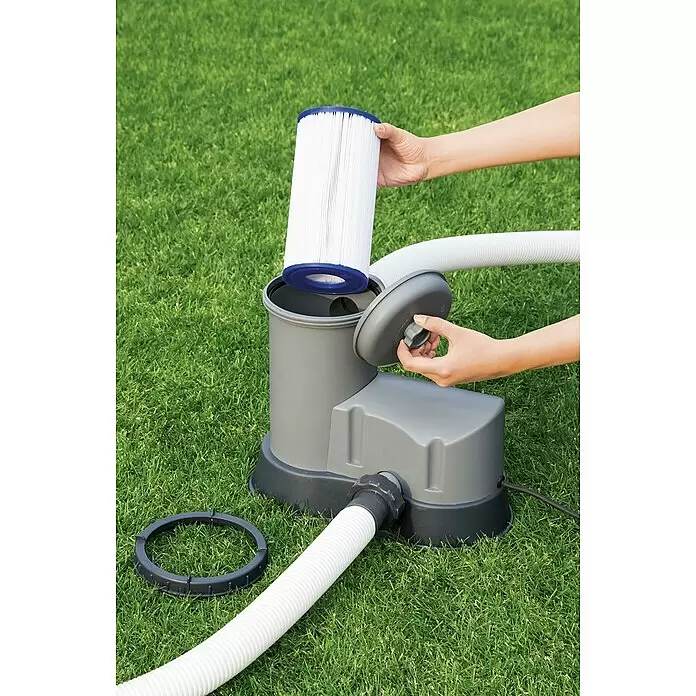 Bestway Filterkartusche Gr. III - Ø x H: 10,6 x 20,3 cm - Eine Hand setzt einen weißen Faltenfilter in eine graue Poolfilterpumpe ein, die mit einem weißen Schlauch verbunden ist.