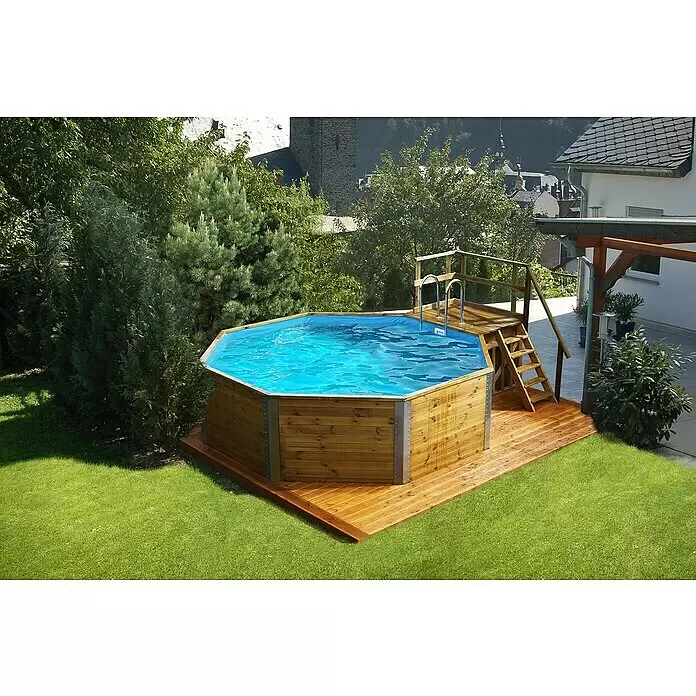 Weka Holz-Pool Acapulco II - L x B x H: 571 x 471 x 116 cm, Braun/Blau, 18.200 l - Achseckiger Aufstellpool aus Holz mit blauem Wasser, integriert in einen Garten mit Holzterrasse und Stufen.