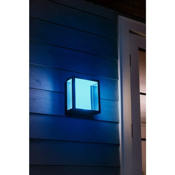 Philips Hue LED-Außenwandleuchte Impress - 8 W, 11,7 x 19 x 24 cm, Schwarz, IP44 - Nahaufnahme einer modernen Außenwandleuchte mit blauem Licht, die eine stilvolle Beleuchtungslösung für den Außenbereich bietet.