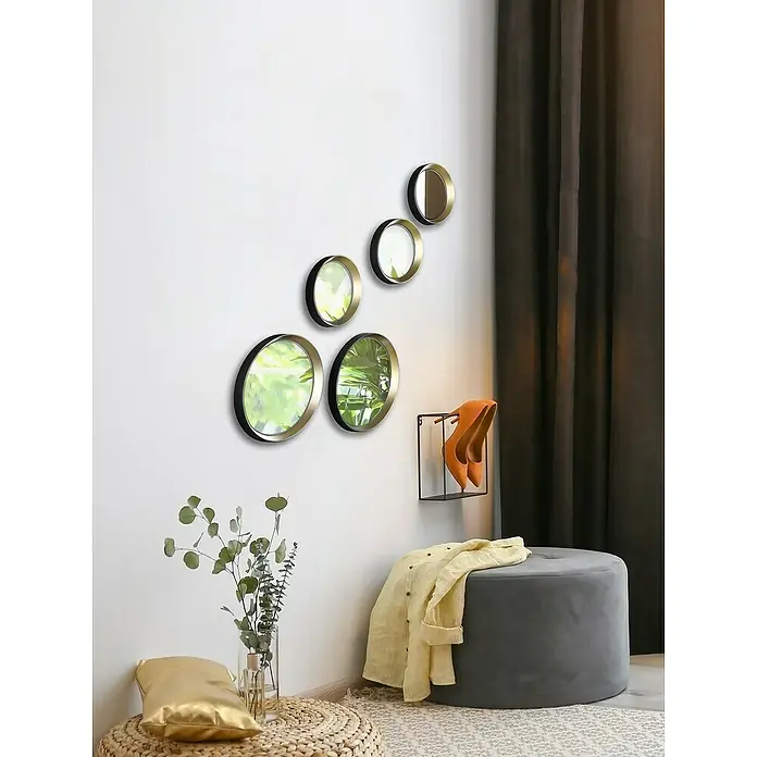 Wandspiegel Vivien - 5 -tlg., Schwarz-Gold - Wanddekoration mit fünf runden Spiegeln, einem grauen Hocker und dekorativen Elementen wie Pflanzen und Schuhen.