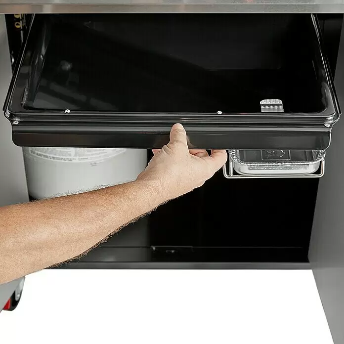 Weber Gasgrill Genesis EX-325S - Grillfläche (B x T): 68 x 48 cm, 11,4 kW, Anzahl Brenner: 3 Stk. - Eine Hand zieht eine schwarze Metall-Fettauffangschale aus einem Grill heraus, darunter ist eine kleine Aluminium-Fettwanne zu sehen.