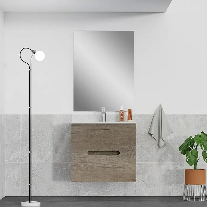 Artysan Mueble bajo de lavabo India Slim - L x An x Al: 39 x 60 x 54,5 cm, Nebraska - Mueble de baño moderno con un gabinete con textura de madera y un espejo arriba, complementado por una elegante lámpara de pie y planta de interior.