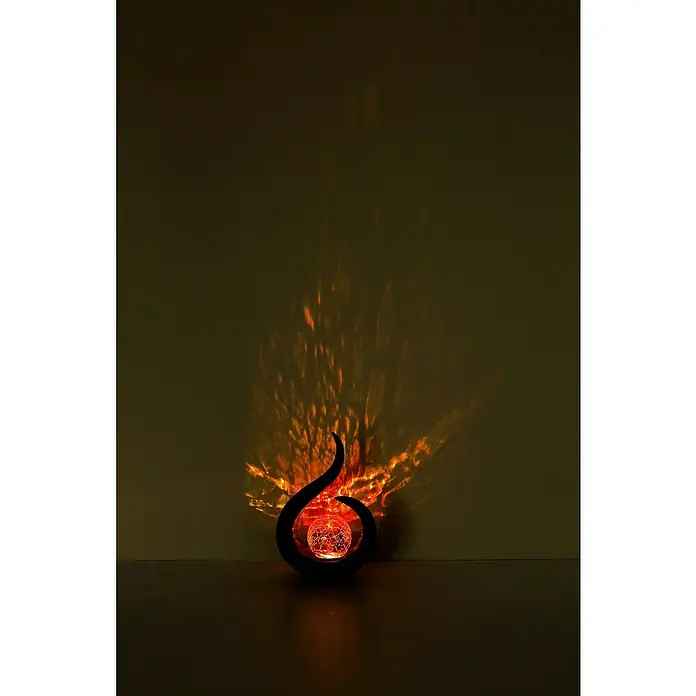 Globo Solar-Dekoleuchte - 0,06 W, L x B x H: 22,5 x 10 x 33,5 cm, Schwarz, IP44 - Nahaufnahme einer dekorativen Lampe mit einer Kugel und einer schwarzen Halterung, die an der Wand ein stimmungsvolles Lichtmuster erzeugt.