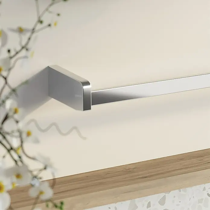 Creabath City Toallero de barra - Ancho: 32 cm, Cromo - Primer plano de un moderno toallero plateado montado en una pared clara con decoración floral. Su diseño minimalista destaca la funcionalidad.