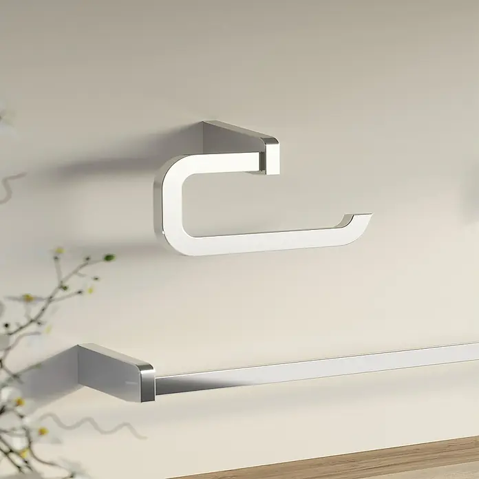 Creabath City Toallero de anilla - Ancho: 22,4 cm, Cromo, Resplandeciente - Un moderno soporte de papel higiénico plateado y un toallero están montados en una pared clara, mostrando elegantes accesorios de baño.