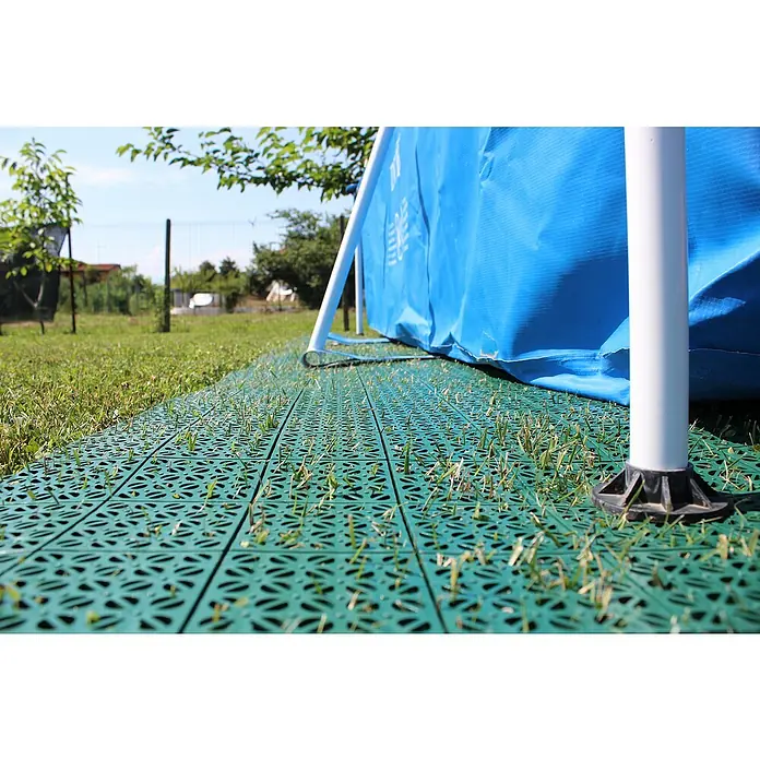 Klickfliese - Polyethylen, 55,5 x 55,5 x 1,1 cm, Grün, 9 Stk. - Grüne Bodenfliesen unter einem blauen Schwimmbecken mit Gras, das durch die Löcher wächst. Praktisch und ästhetisch für den Garten.