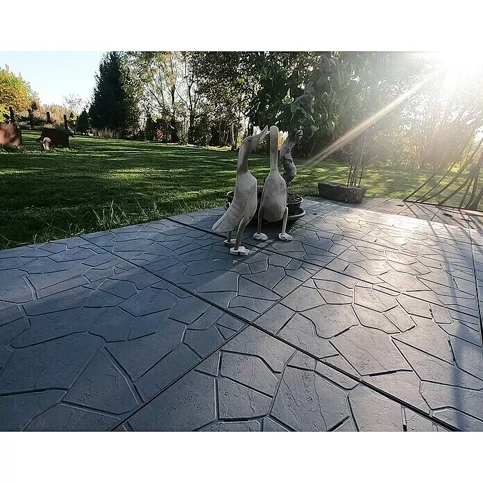 WPC-Fliese Snaptile - Anthrazit, 38 x 38 x 2,5 cm, 1 Stk. - Zwei helle Holzentenfiguren auf einer texturierten Terrasse in einem sonnigen Garten.
