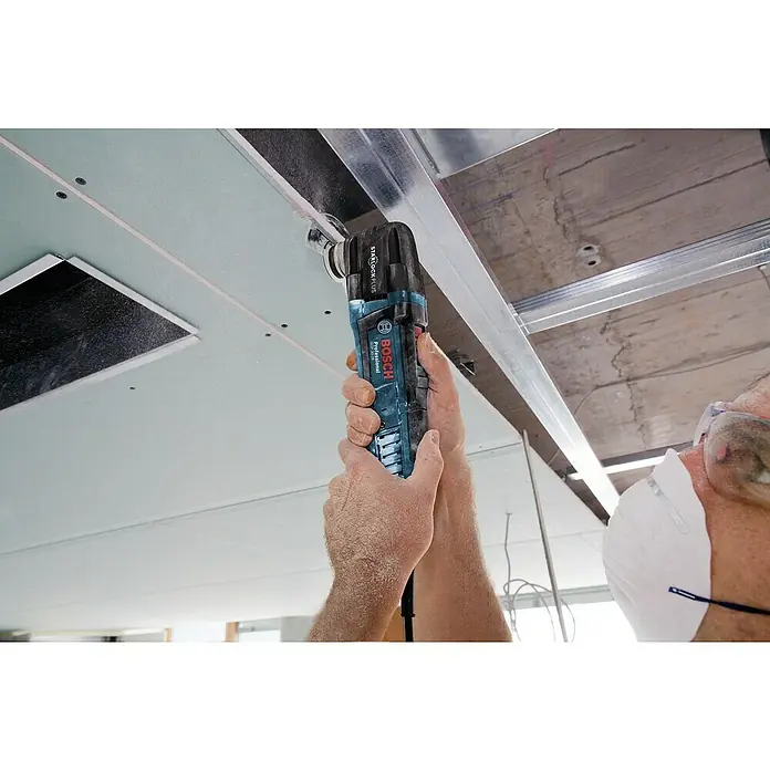 Bosch Professional Elektro-Multifunktionswerkzeug GOP 30-28 - 300 W, STARLOCK-Plus-System - Mann mit Bosch Profi-Multifunktionswerkzeug beim Arbeiten an einer Deckenkonstruktion.\n