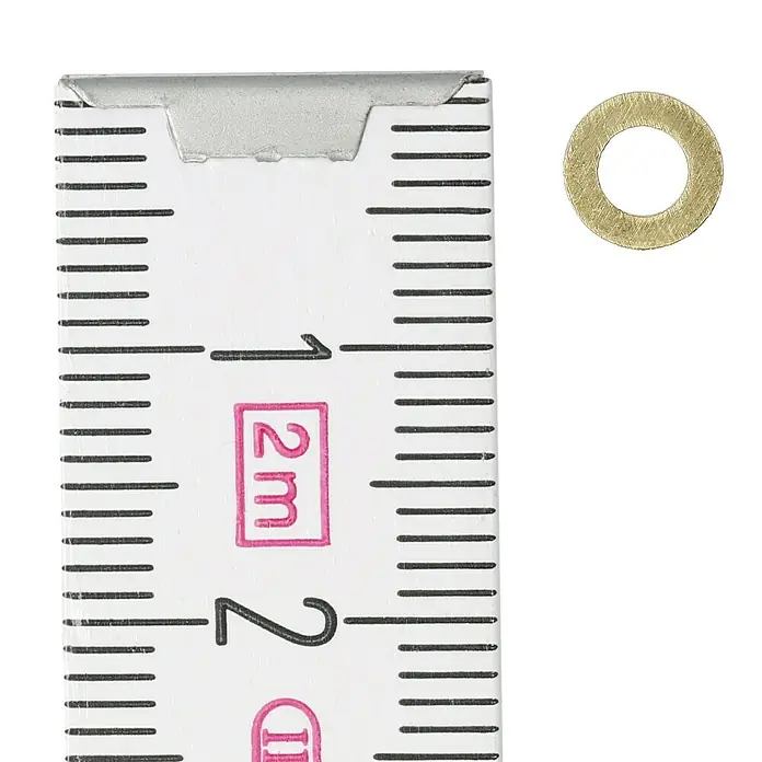 Unterlegscheibe - Innendurchmesser: 3,2 mm, Außendurchmesser: 7 mm, Messing, Blank, 26 Stk. - Nahaufnahme einer Unterlegscheibe neben einem Zollstock zur Größenorientierung.