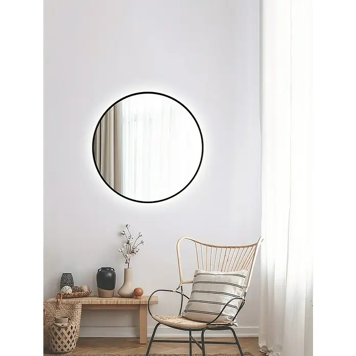 DSK Lichtspiegel Silver Barbier - Durchmesser: 80 cm, Schwarz, Leuchtmittel - Ein minimalistischer Raum mit einem runden Spiegel an der Wand, der das Tageslicht einfängt und eine beruhigende Atmosphäre schafft.