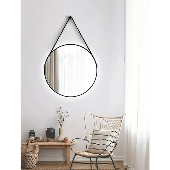 DSK Lichtspiegel Silver Barbier - Durchmesser: 80 cm, Schwarz, Leuchtmittel - Stilvolles Interieur mit einem runden Spiegel mit schwarzem Rahmen, der an einer weißen Wand hängt, neben einem Rattan-Stuhl und einer Bank mit Dekoration.