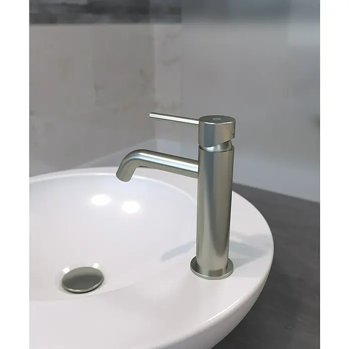 IO Sirio Grifo de lavabo - Níquel - Primer plano de un grifo plateado moderno sobre un lavabo blanco, con un diseño minimalista y elegante.