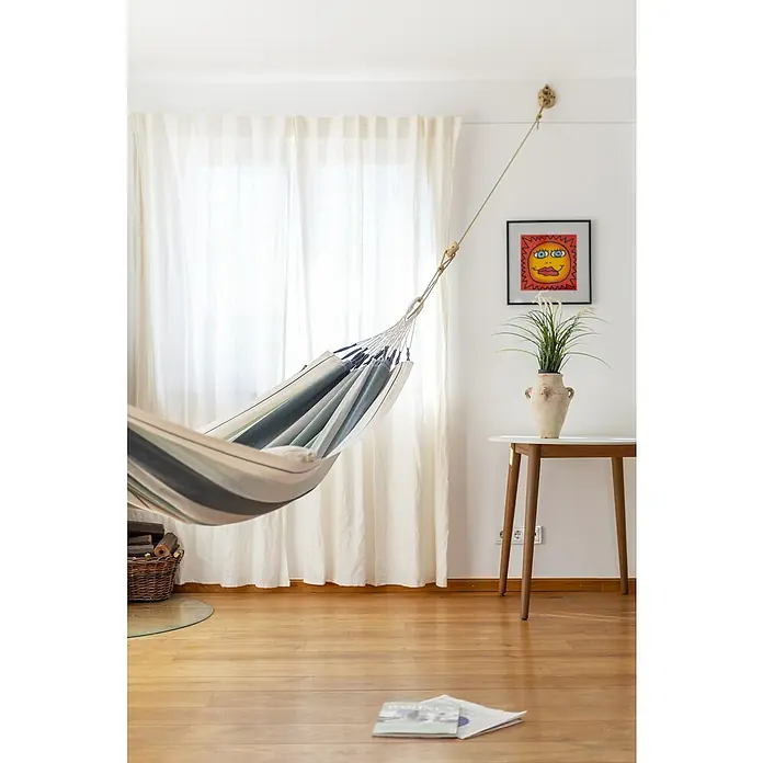 La Siesta Hängematte Modesta - L x B: 300 x 140 cm, Olive, Single - Die gestreifte Hängematte hängt lässig im Raum und bietet einen entspannten Ort zum Verweilen. Das helle Zimmer mit den Holzböden wirkt einladend.