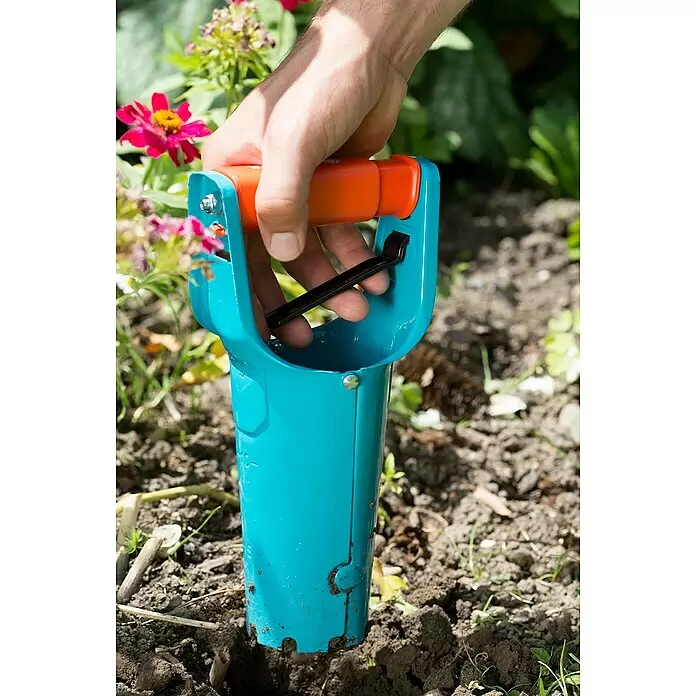 Gardena Hand-Blumenzwiebelpflanzer - Länge: 250 mm, Stahl - Hand nutzt blauen und orangen Blumenzwiebelpflanzer, um in Erde zu graben.