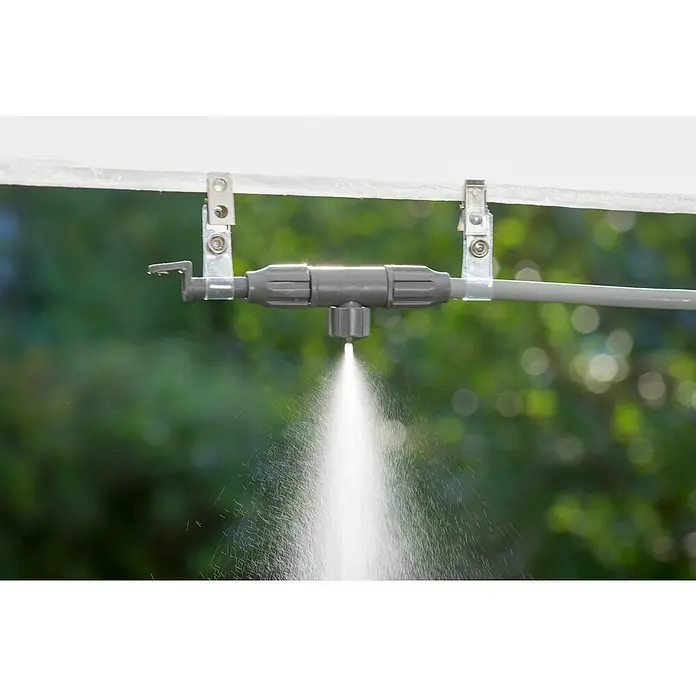 Gardena City Gardening SprühdüsePassend für: Gardena city gardening Outdoor Luftkühler-Set - Nahaufnahme einer Bewässerungsanlage, die Wasser versprüht, montiert an einem transparenten Rohr mit grüner Vegetation im Hintergrund.