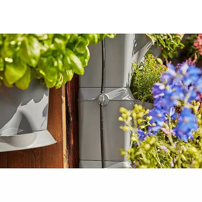 Gardena Bewässerungs-Set NatureUp! Vertikal Wasserhahn - Passend für: Bewässerung von bis zu 27 Pflanzen/9 vertikalen Pflanzbehältern - Graue gestapelte Vertikalpflanzgefäße mit Bewässerungsschlauch, gefüllt mit Pflanzen und bunten Blumen.