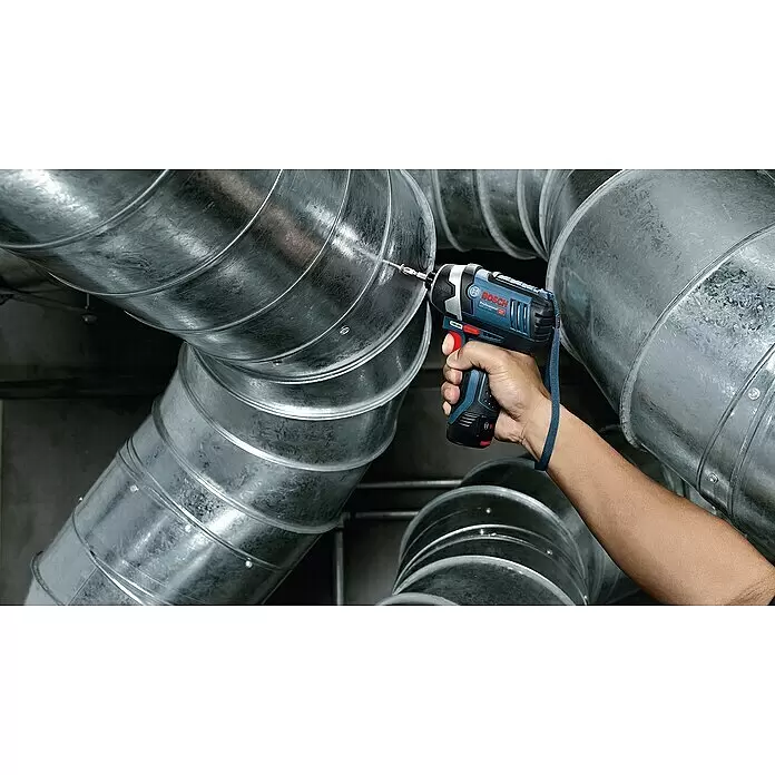 Bosch Professional Akku-Drehschlagschrauber - 12 V, Ohne Akku - Eine Person verwendet einen blauen und schwarzen Bosch Schlagschrauber, um in glänzende Metalllüftungsrohre zu bohren.