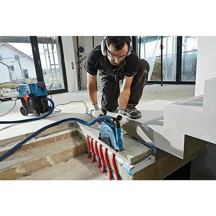 Bosch Professional Absaugvorrichtung GDE 230 FC-T - Passend für: Bosch Winkelschleifer GWS-Serie mit Ø 230 mm - Der Bosch Mauernutfräse ist mit einem Staubsauger verbunden, um eine saubere und effiziente Staubabsaugung bei Bauarbeiten zu gewährleisten.
