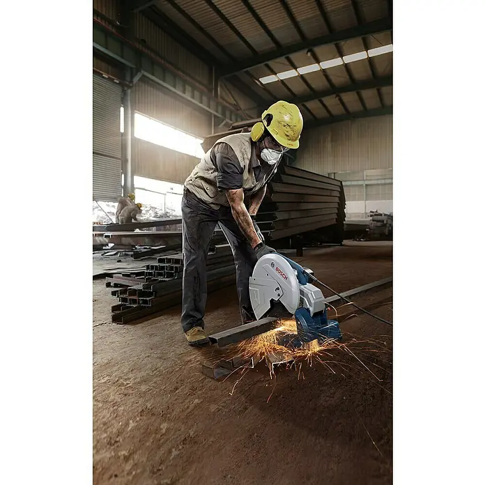 Bosch Professional Trennschneider GCO 14-24 J - 2.400 kW, Leerlaufdrehzahl: 3.800 U/min, Durchmesser Scheibe: 355 mm - Ein Mann arbeitet mit einer Bosch Metallsäge, Funken fliegen, während er Metall schneidet. Persönliche Schutzausrüstung wird getragen.