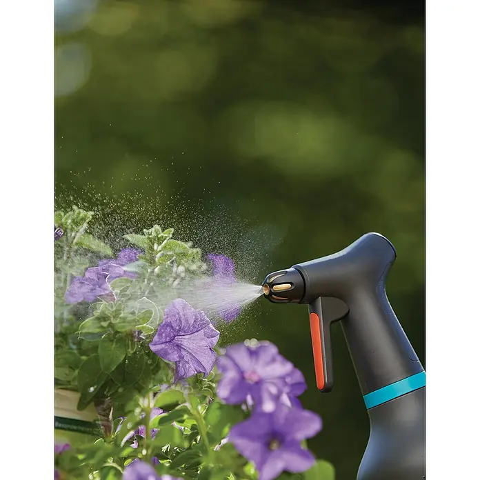 Gardena Drucksprüher Set - Bestehend aus: Drucksprüher Comfort 5 l & Pumpsprüher 0,75 l - Der Gardena Akku-Drucksprüher wird hier beim Bewässern von lila Blumen in Nahaufnahme gezeigt.
