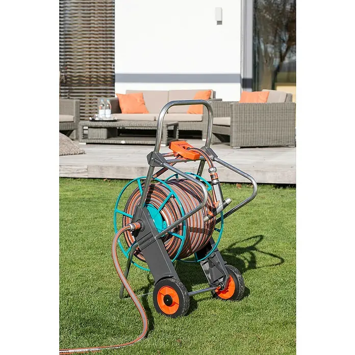 Gardena Schlauchwagen 100 - Metall, Schlauchkapazität: 100 m, 13 mm (1/2") - Gartenschlauchwagen mit aufgerolltem Schlauch im Garten.