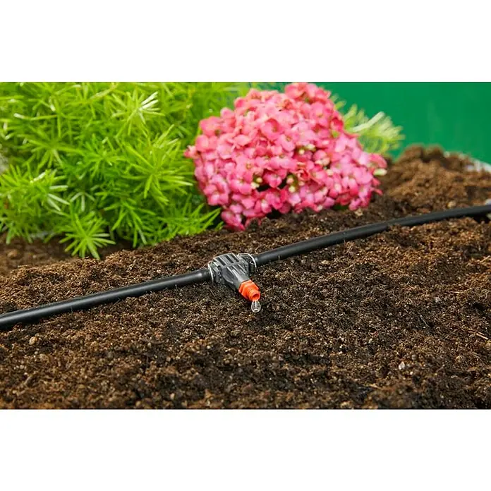 Gardena Micro-Drip Bewässerungs-Set Pflanztöpfe M automatic Start-Set - Passend für: Bis zu 7 Blumentöpfe und 3 Pflanztröge - Nahaufnahme eines Bewässerungssystems im Garten mit Blumen und üppigem Grün im Hintergrund.