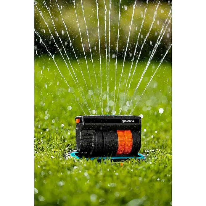 Gardena Sprinklersystem Viereckregner OS 140 - Max. Regnerfläche: 140 m², 1 -tlg. - Nahaufnahme eines Gardena Viereckregners, der Wasser versprüht und Rasen bewässert, mit besonderem Fokus auf Funktionalität.
