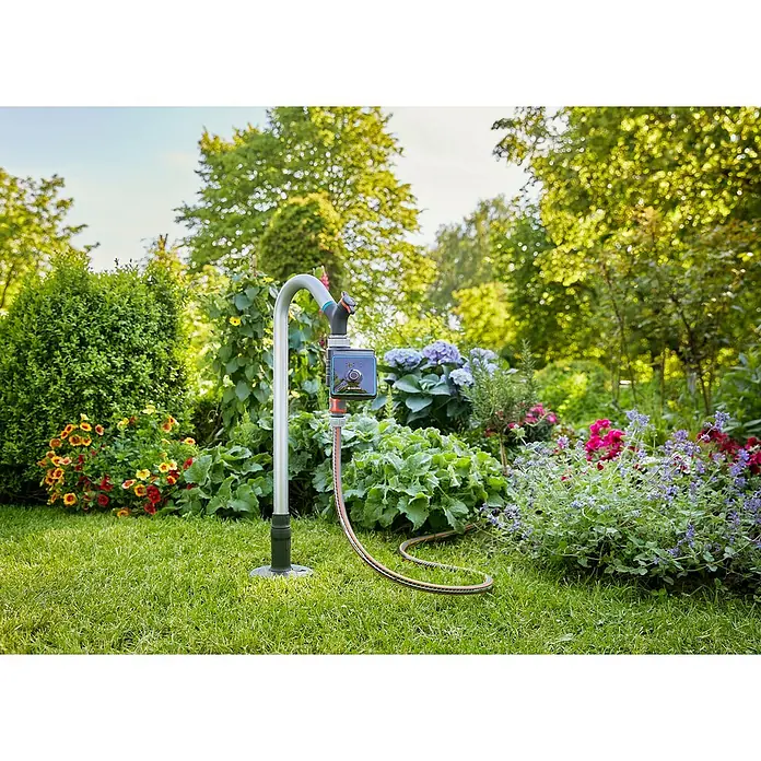 Gardena Sprinklersystem Wasserhahn - Metall - Der Gardena Bewässerungsautomat steht auf dem Rasen, umgeben von bunten Blumen und üppigem Grün. Perfekt für die automatische Gartenbewässerung.