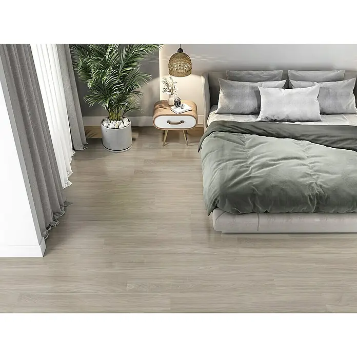 Pavimento porcelánico Bosco - 22,5 x 119,5 cm, Otoño, Mate, Rectificado - Acogedor dormitorio con una cama cómoda, una mesita de noche y una elegante planta de interior que añade un ambiente sereno y relajante.