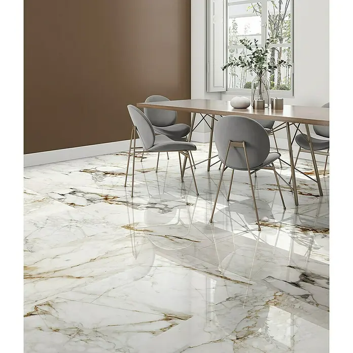 Halcón Pavimento porcelánico Barnaby - 60 x 120 cm, Blanco, Brillante, Rectificado, Espesor: 9 mm - Un comedor con una elegante mesa de comedor y sillas grises sobre un lujoso suelo de mármol blanco con toques dorados.