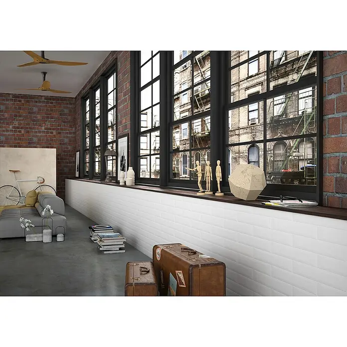 Modern Style Wandfliese Manhattan Biselado Blanco - 7,5 x 15 cm, Weiß, Matt - Dieses Bild zeigt einen Raum im Loft-Stil mit Vintage-Akzenten, wie z.B. den braunen Koffern. Das Design bietet eine urbane und gemütliche Atmosphäre.