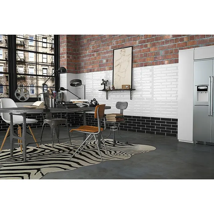 Modern Style Wandfliese Manhattan Biselado Negro - 7,5 x 15 cm, Schwarz, Glänzend - Büro mit Esstisch, Stühlen, Zebra-Teppich, Schreibtischlampe und Kühlschrank in einem industriellen Interieur mit Ziegelwand und großen Fenstern.