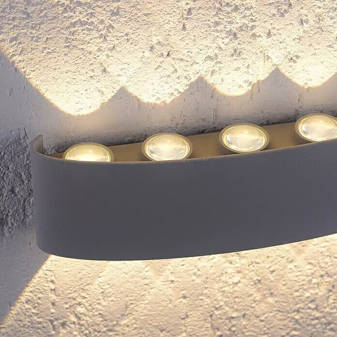 Paul Neuhaus LED-Wandleuchte Carlo - 18 W, L x B x H: 27 x 4,7 x 8 cm, Stahl - Geschwungene dunkelgraue LED-Wandleuchte, die eine strukturierte weiße Wand nach oben und unten beleuchtet.