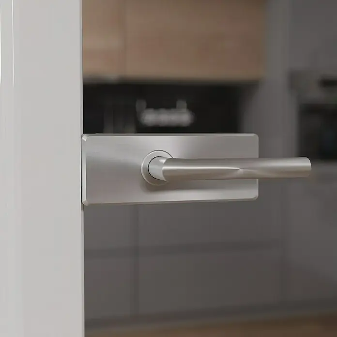 Diamond Doors Glasdrehtür Grey - 834 x 1.972 mm, DIN Anschlag: Links/Rechts, Klarglas - Nahaufnahme eines modernen Türgriffs aus gebürstetem Metall, der an einer weißen Tür befestigt ist. Elegantes Design für Innentüren.