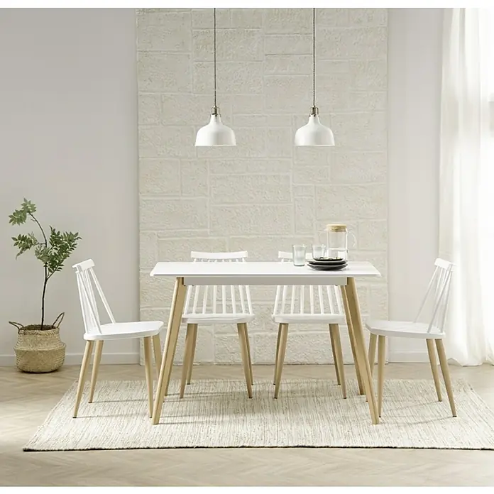 Silla Nova - L x An x Al: 45 x 42 x 78 cm, Blanco - Una mesa de comedor moderna con cuatro sillas blancas sobre una alfombra clara, iluminada por dos lámparas colgantes.