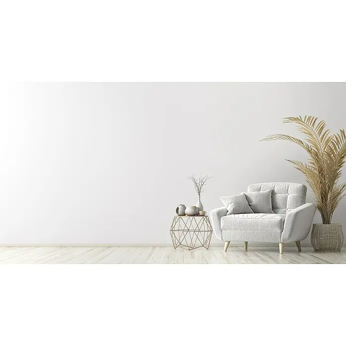 swingcolor Wandfarbe Ausbesserungsspray Arktisweiß Plus - Schneeweiß, Matt, 150 ml - Einrichtung mit einem grauen Sessel, Beistelltisch und dekorativen Pflanzen vor einer weißen Wand. Die Einrichtung wirkt modern und einladend.