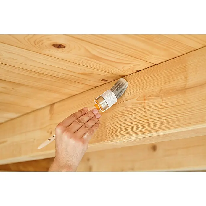 swingcolor Holzgel - Kiefer, Seidenglänzend, 3 l - Nahaufnahme einer Person, die eine Holzdecke mit einem Farb Pinsel streicht. Das Werkzeug ist von hoher Qualität und sorgt für ein gleichmäßiges Ergebnis.