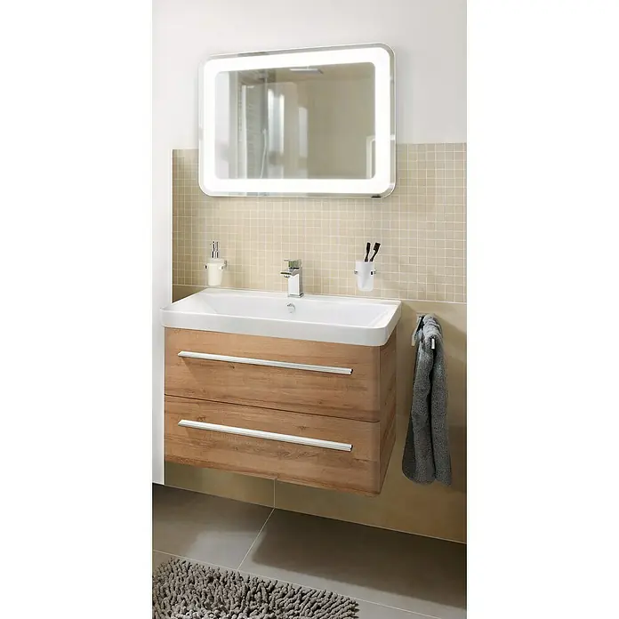 Camargue Modern 3.0 Badmöbel-Set MO80B2 - Gesamtbreite Badmöbel: 80 cm, Berg Eiche, Matt, 3 -tlg. - Ein moderner Waschtisch mit Holzstruktur und einem beleuchteten Spiegel darüber. Das Bad ist mit beigen Fliesen und einem grauen Teppich ausgestattet.