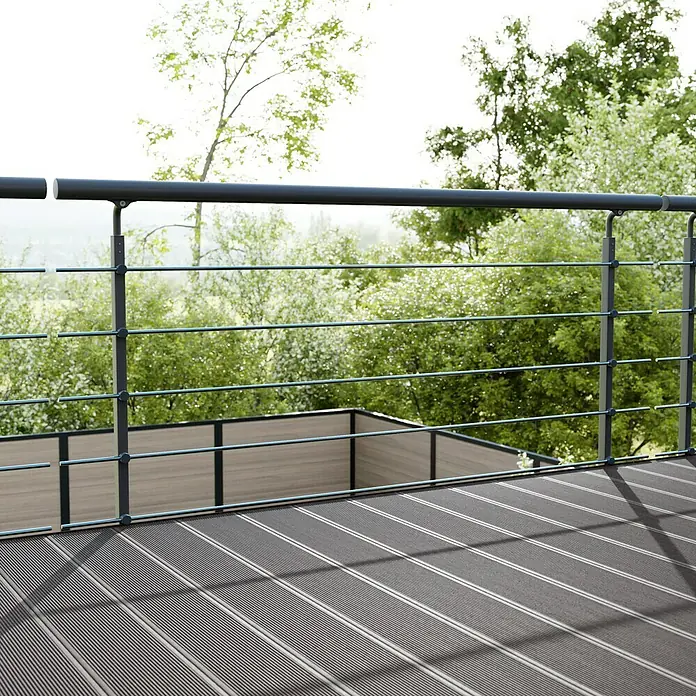 Solid Elements Juego de barandilla - Aluminio, Antracita, Largo: 1.500 mm, Montaje lateral - Primer plano de un balcón con suelo gris y una barandilla moderna, que ofrece vistas a la exuberante naturaleza verde.