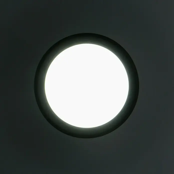 Ritter Leuchten LED-Deckenleuchte rund - 14 W, Schwarz, Tageslichtweiß - Nahaufnahme einer runden Deckenleuchte mit schwarzem Rahmen, die helles, weißes Licht in einem dunklen Raum ausstrahlt.