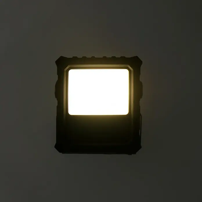 Profi Depot LED-Strahler - 10 W, 700 lm, 4.000 K, L x B x H: 5,8 x 15,7 x 22,4 cm, IP65 - Nahaufnahme eines leuchtenden, rechteckigen LED-Flutlichts mit einem robusten, schwarzen Gehäuse.