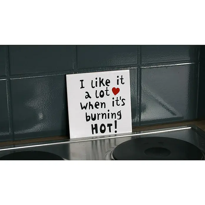 SCHÖNER WOHNEN-Farbe Pep up Renovierfarbe für Wand- & Bodenfliesen - Anthrazit, Glänzend, 1 l, Wasserbasiert - Dekorativer Fliesenaufkleber mit der Aufschrift "I like it a lot when it's burning HOT!", der an einer Küchenwand über einem Herd angebracht ist.