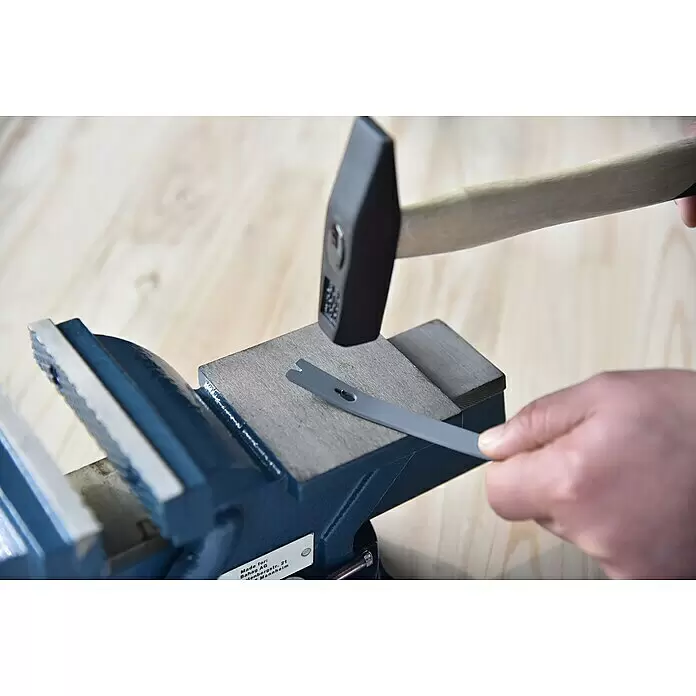 Schraubstock - 125 mm, 360 ° drehbar, Metall - Eine Person hämmert eine graue, geschlitzte Brechstange auf einem blauen Werkstatt-Schraubstock.